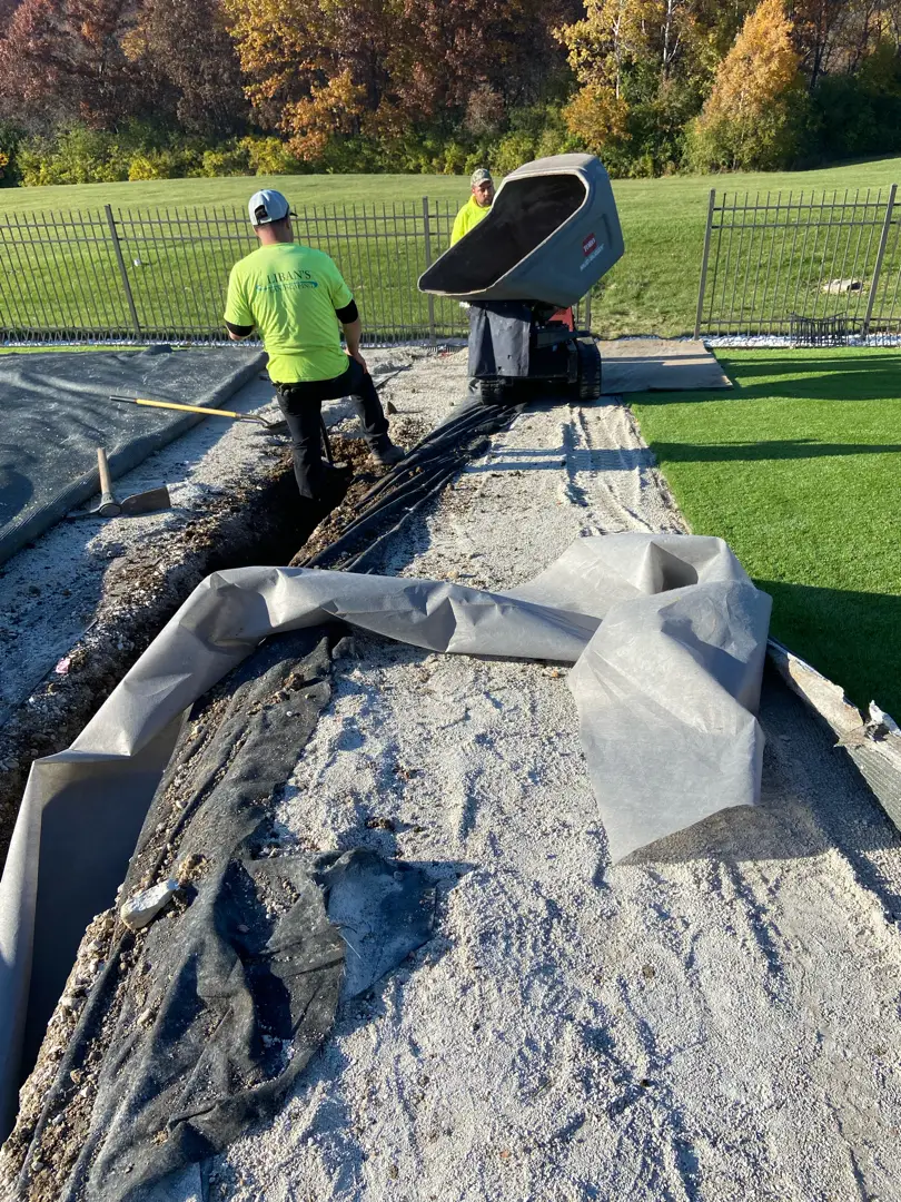 The picture captures our team in action installing a PVC French drain system in Milwaukee, WI. The installation features perforated PVC pipes surrounded by gravel, designed to effectively channel and manage water flow. This system helps prevent water accumulation and flooding, ensuring optimal drainage and protection for the property. The collaborative effort ensures a precise and efficient setup, blending seamlessly with the landscape.