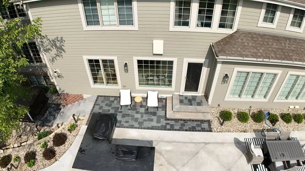 "Luxurious poolside patio in Hartland, Wisconsin, complete with sleek stone steps and a stylish bar. This inviting outdoor space is perfect for relaxation and entertaining, combining elegance with functionality. #HartlandWI #PoolsidePatio #StoneSteps #OutdoorBar"