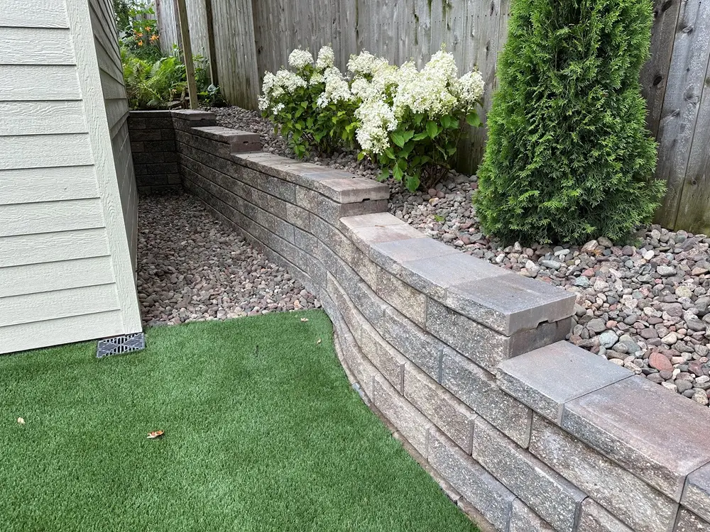 "Elegant retaining wall in Whitefish Bay, Wisconsin, showcasing a blend of style and durability. Adds both charm and functionality to the landscape, complementing the natural beauty of the area. #WhitefishBay #RetainingWall #LandscapeDesign"