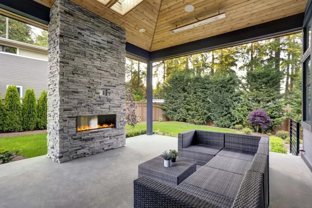 "Stylish covered outdoor living area extension featuring a cozy fireplace. This addition enhances your outdoor space with year-round comfort and elegance, perfect for relaxation and entertaining. #OutdoorLiving #CoveredPatio #Fireplace #HomeExtension"